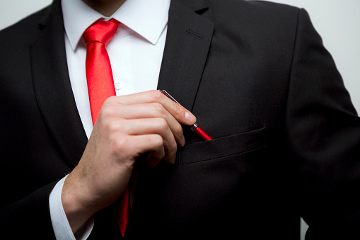 Unrecognizable businessman taking red pen from the pocket