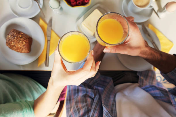 istock Young couple is drinking orange juice for breakfast – overhead view 908224056