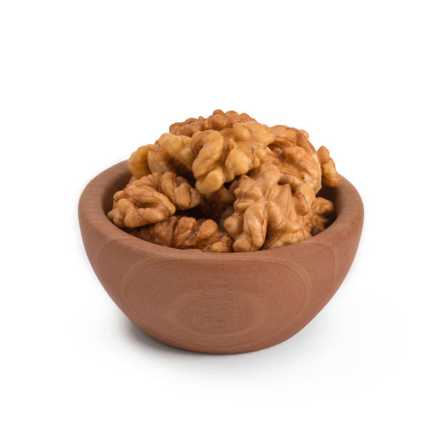 istock Walnuts shelled in a bowl isolated on white background. Side view. Walnut kernels in a bowl. 908227658