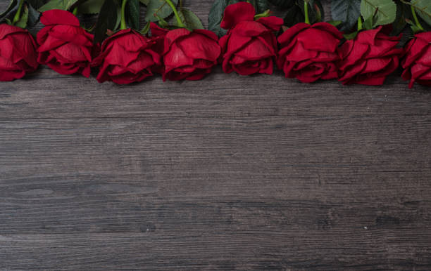 istock Roses on wooden board, valentines day background 908230522