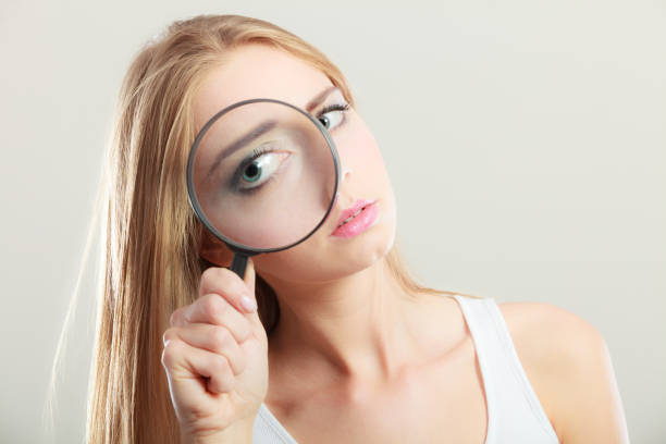 istock girl holding on eye magnifying glass loupe 908231230