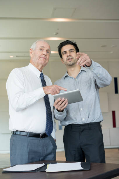 istock Junior and Senior Coworkers Viewing Presentation 908231342