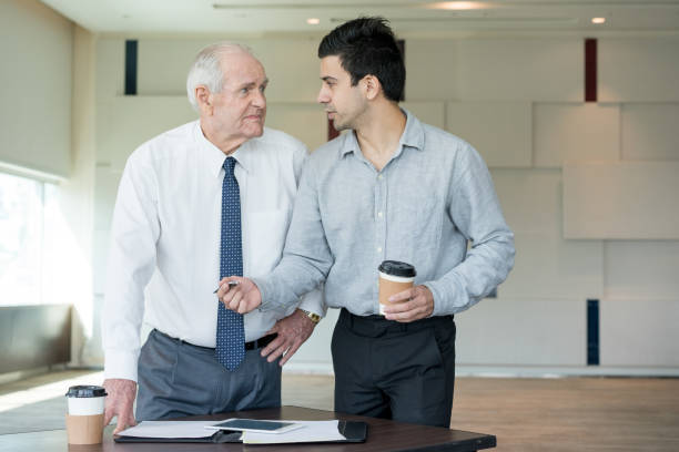 young manager offering his idea to skeptical boss - pen business person men standing imagens e fotografias de stock