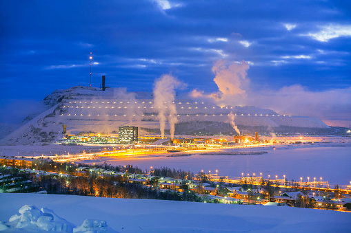 White landscape: lights of an Arctic Circle mining town with illuminated mine operations and smoke stacks on Kiirunavaara in the background (Note: the scene has dramatically changed with the relocation of the town)