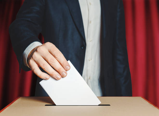 istock Man Voiter Putting Ballot Into Voting box. Democracy Freedom Concept 908231958
