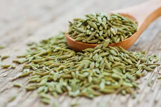 Green anise in a wooden spoon closeup