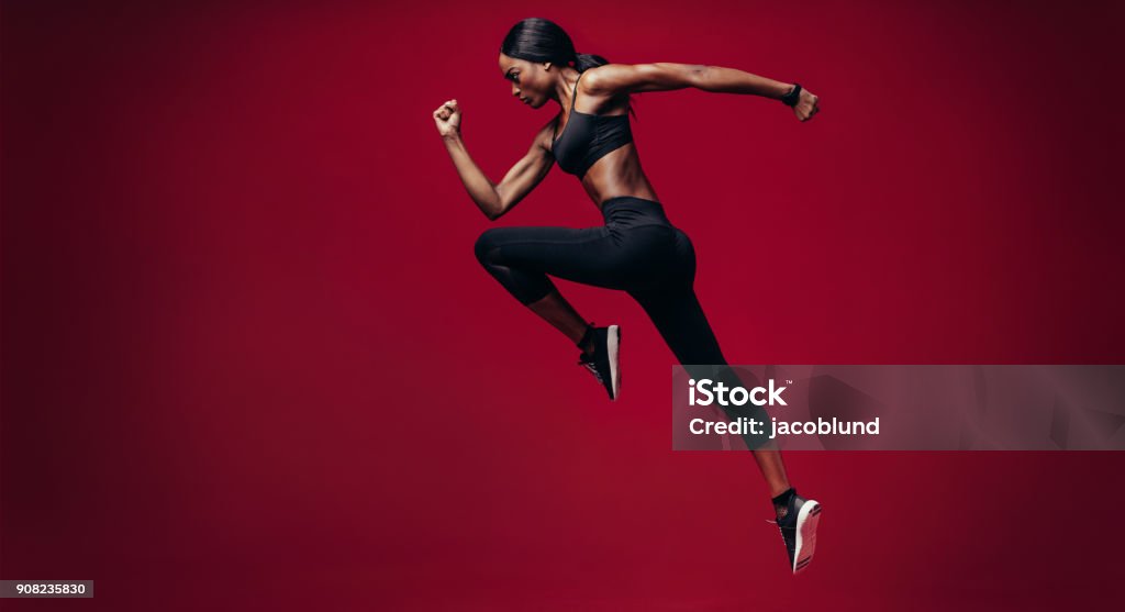 Mujer de deportes funciona sobre fondo rojo - Foto de stock de Correr libre de derechos