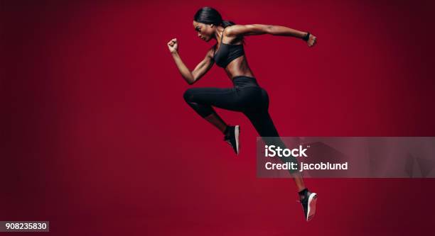 Sports Woman Running Over Red Background Stock Photo - Download Image Now - Running, Gym, African Ethnicity