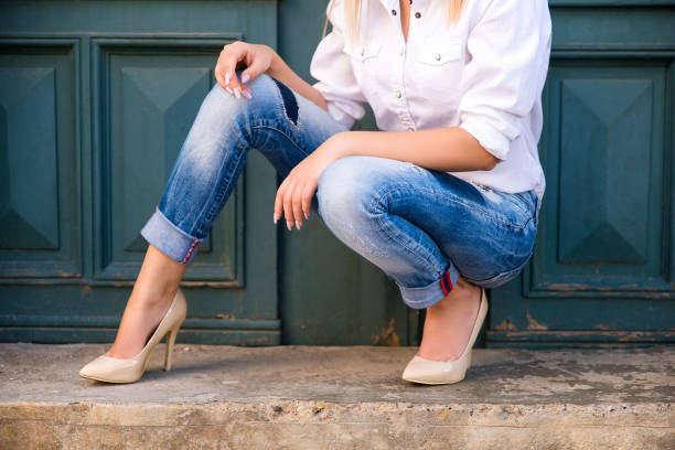 istock Woman in denim pants and high heels 908238016