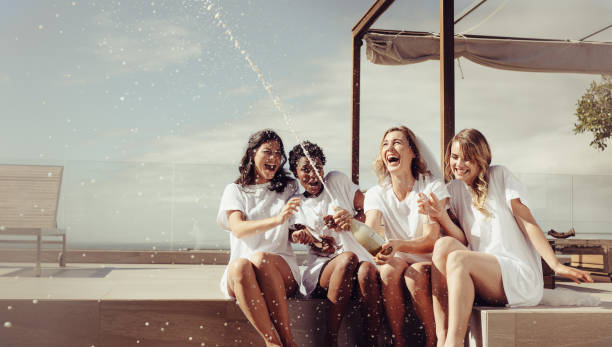 la novia alegre y damas de honor celebrando la despedida de soltera - outdoors drinking women friendship fotografías e imágenes de stock