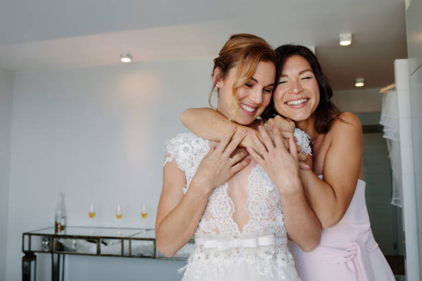 istock Happy bridesmaid giving a tender hug to bride 908238236