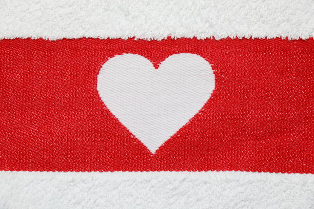 istock Embroidered white heart on a red background 908238364