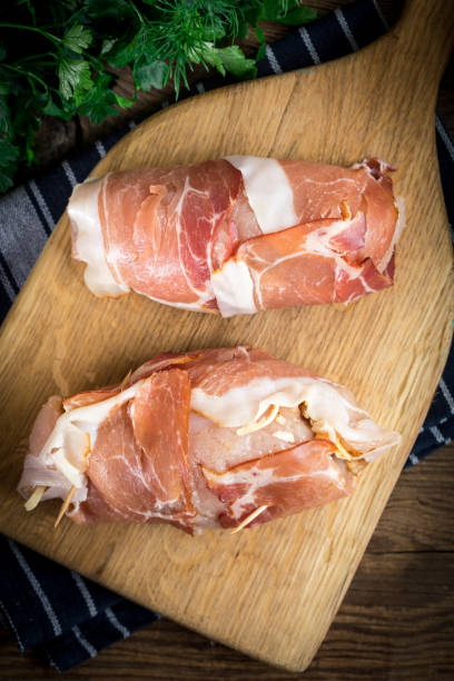 istock Raw chicken breast stuffed with champignon wrapped with bacon. 908238796