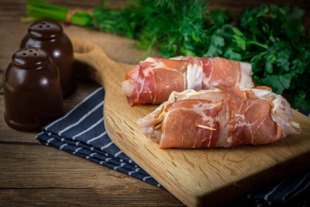istock Raw chicken breast stuffed with champignon wrapped with bacon. 908238812