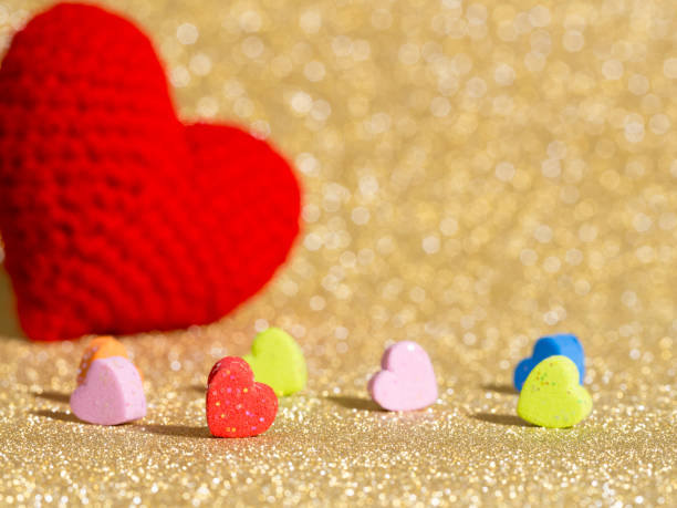 istock Handmade red yarn heart on gold abstract background. Copy space for text, Valentines day, love concept and love background 908244306
