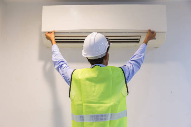 spécialiste nettoie et répare le climatiseur mural. - air conditioner electricity repairing furnace photos et images de collection