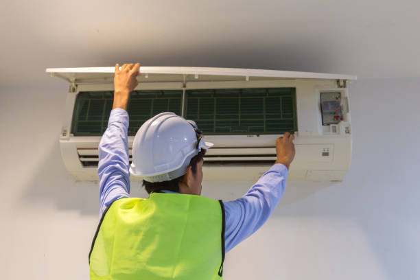 especialista limpia y repara el acondicionador de aire de pared. - furnace lighting technique air conditioner repairing fotografías e imágenes de stock