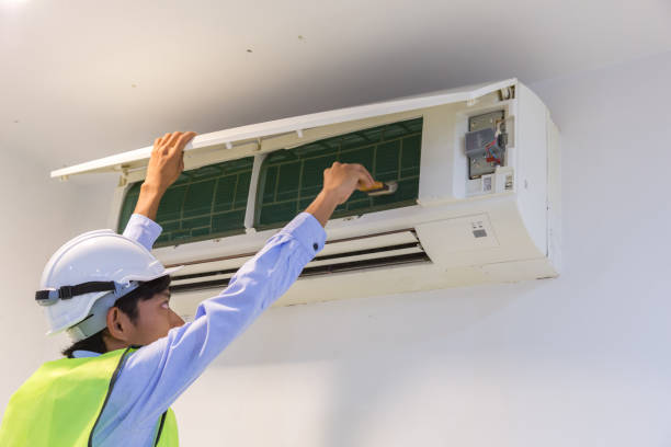 especialista limpia y repara el acondicionador de aire de pared. - furnace lighting technique air conditioner repairing fotografías e imágenes de stock