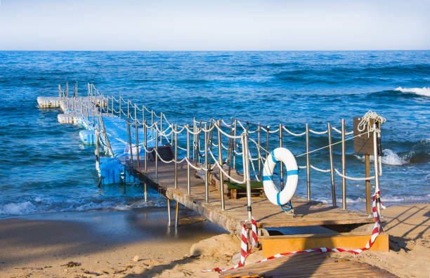 istock Life buoy hanging on pier and sea background 908249080