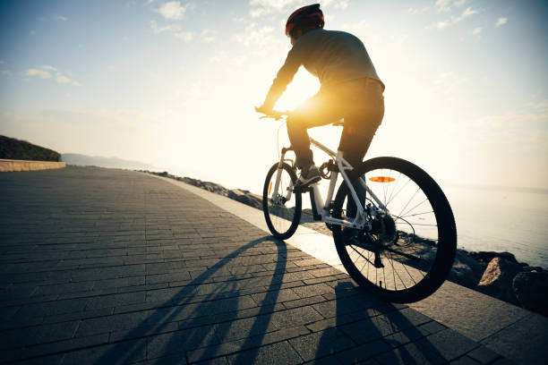 istock cyclist riding bike in the sunrise coast path 908249680