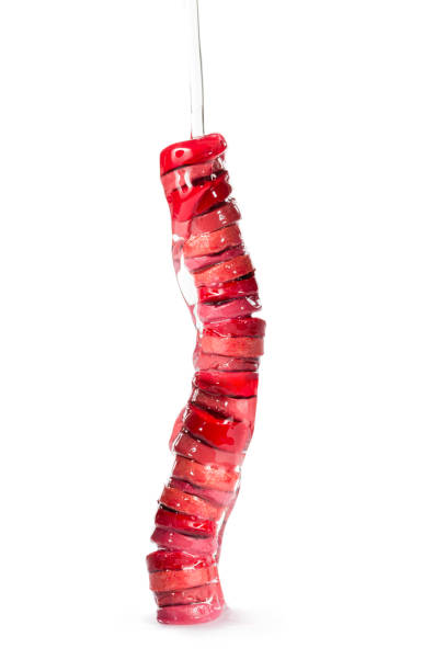 Stack of sliced moisturizing lipsticks with nourishing oil, pouring on them