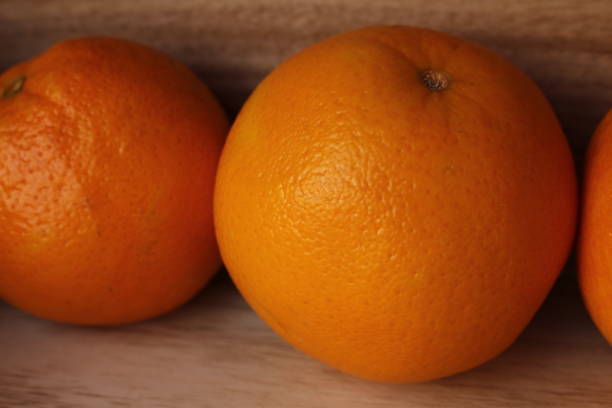 istock Fresh whole oranges in a box on a wooden background 908252330