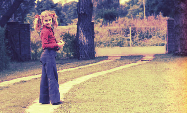 Vintage image of a girl standig outdoors and looking back to camera.