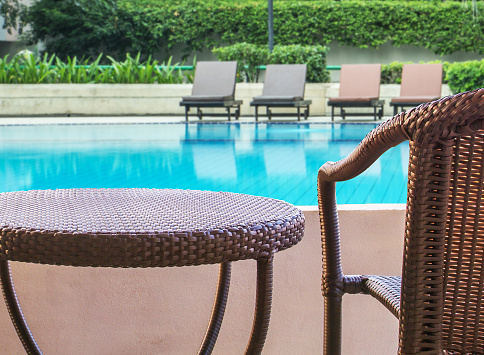 rattan chair on balcony hotel with swimming pool view