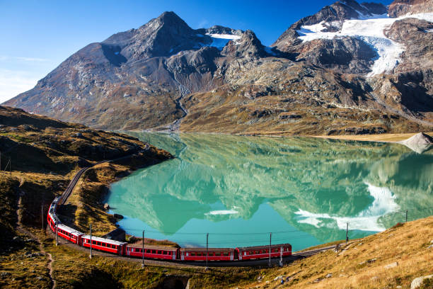 swiss train in the alps mountains in switzerland around ospizio bernina - fotografia de stock