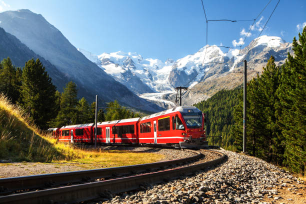 swiss train in the alps mountains in switzerland around ospizio bernina colourful summer daytime images small train in large landscape switzerland tourist places stock pictures, royalty-free photos & images