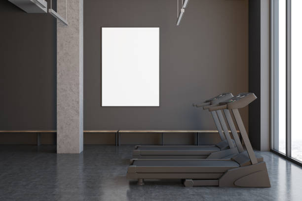 istock Two treadmills in a gray room, close up side 908278676