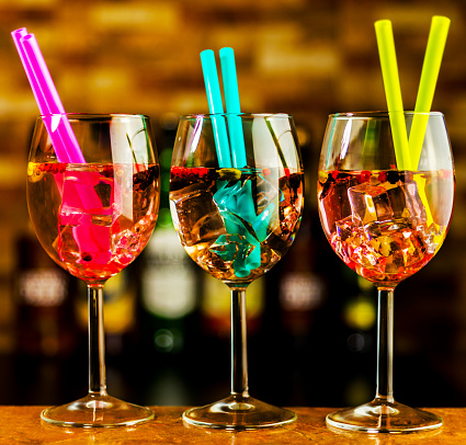 Tasty and colorful drinks based on various alcohols, syrups, and liqueurs, unique effect of the bartender's work, party night