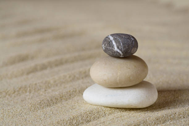 istock Pile of balanced stones on sand 908279094