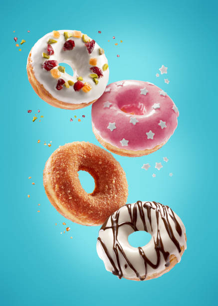 Donuts selection flying on blue background. Various doughnuts isolated on colorful background stock photo