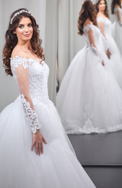 istock satisfied young bride, one person, looking at self, in mirror, happy 908286716