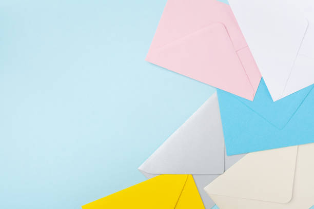 istock Border from colorful envelopes on blue table top view. Mockup for business mail, blogging and office correspondence. Flat lay. 908289852