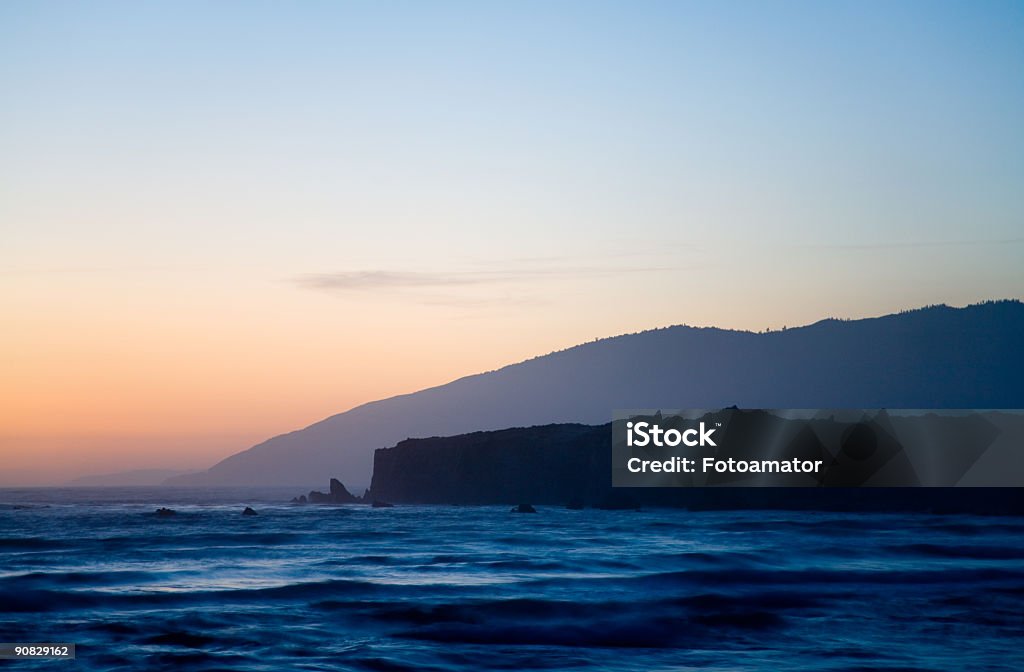 Mountains and ocean Mountains and ocean at sunset with clear sky. Abandoned Stock Photo