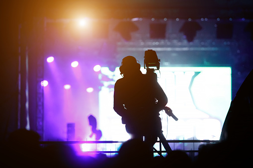 Silhouette of the cameraman working concert, music festival