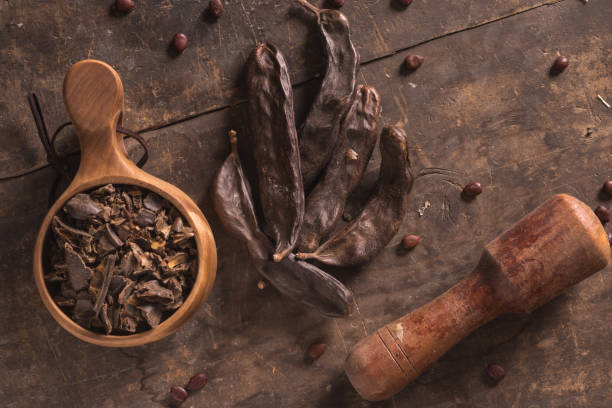 istock carob pods on wood 908299494