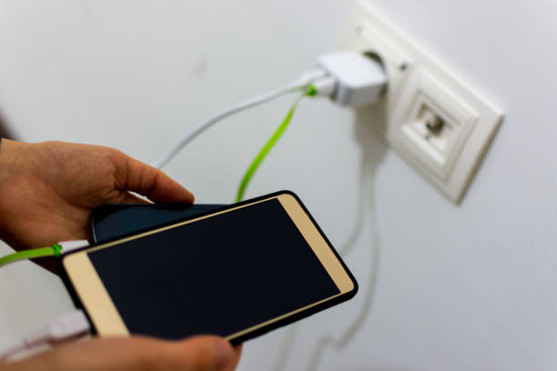 istock Woman pluging smartphone for charging 908299784