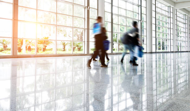 istock Motion blurred people walking in modern office 908304010