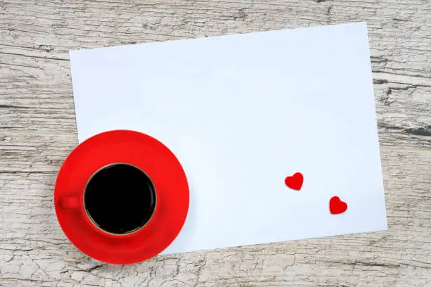 valentine's day greeting card, red coffee cup and heart shapes on white wooden planks