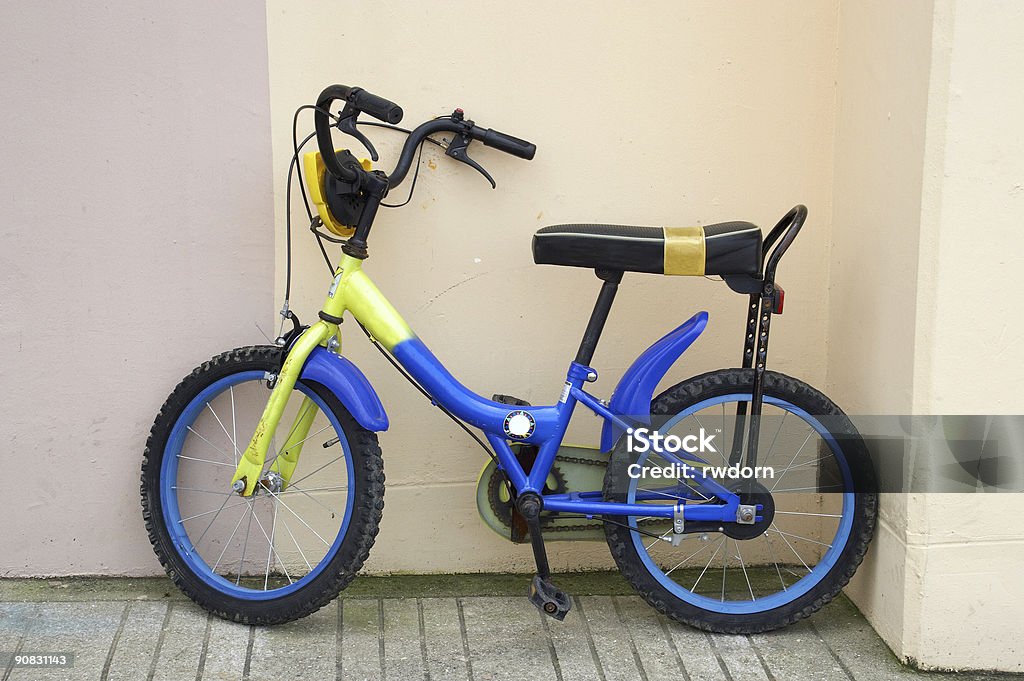 Bambino bicicletta Appoggiarsi parcheggiato su una parete. - Foto stock royalty-free di Abbandonato