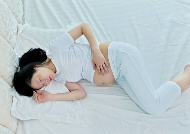 istock Pregnant woman sleeping in bed 908313758
