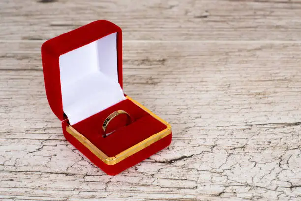golden ring in gift box on rustic wooden table