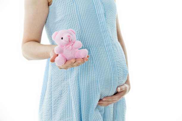 istock Pregnant woman holding a small teddy bear 908317106
