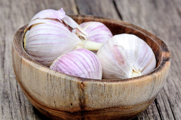 istock Fresh garlic in a wooden bowl on rustic table 908327300