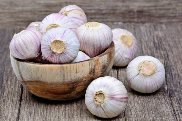 istock Fresh garlic in a wooden bowl on table 908330998