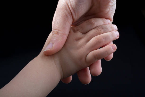 istock Adult and child hold hands 908340018