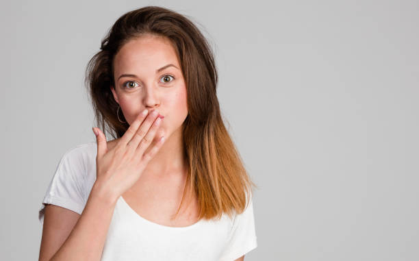 istock young brunette sends an air kiss 908340828